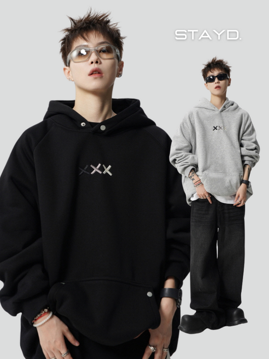 韓国系メンズファッションブランドSTAYDの黒とグレーのストリートフーディーを着用したモデルが、クールな雰囲気で都会的にポージング。韓国、メンズ、カジュアル、ストリートコーデに最適。