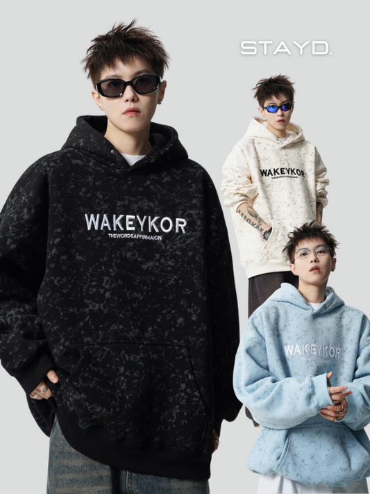 韓国系メンズブランドSTAYD.のブラックストリートフーディーを着用し、サングラスをかけたモデルが都会的にポーズ。カジュアルでラフなストリートスタイルコーデを演出。
